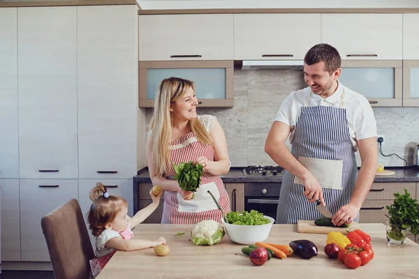 A  family prepares food from vegetables in the kitchen. — Stock Photo, Image