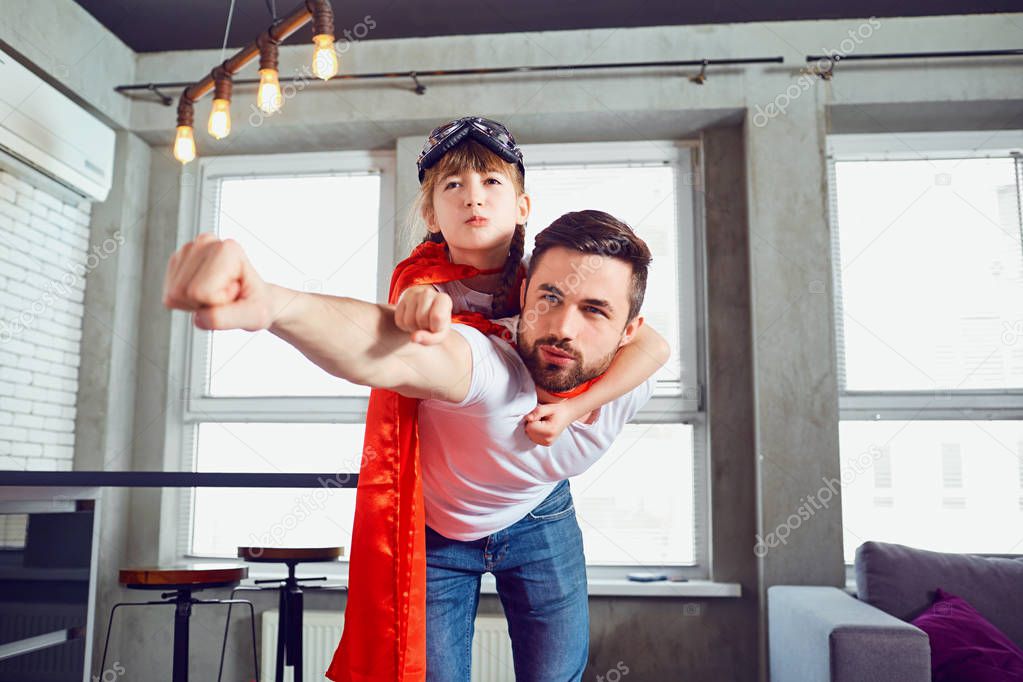 Father and daughter kid in suits super hero play in the room.