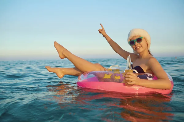 산타 모자 수영 바다 수영에 대 한 원에 있는 여자 — 스톡 사진