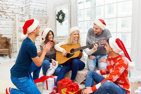 Un grupo de amigos con guitarra y cantando en casa en Navidad — Foto de Stock