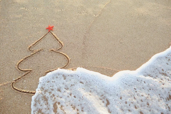 Albero di Natale dipinto nella sabbia sulla spiaggia . — Foto Stock