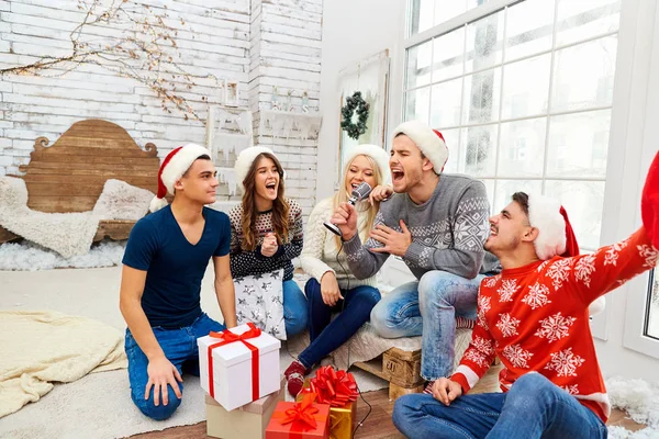 Un grupo de amigos con regalos en una fiesta de Navidad —  Fotos de Stock