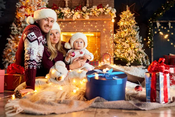 Happy family with a baby in a Christmas room. — Stock Photo, Image