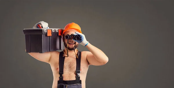 Witzige dickbärtige Bauarbeiter mit Fernglas. — Stockfoto