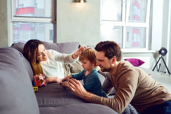 Gelukkige familie spelen met het kind op de kamer. — Stockfoto