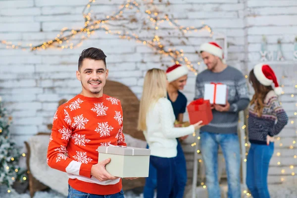 Un grupo de amigos con regalos en una fiesta de Navidad — Foto de Stock