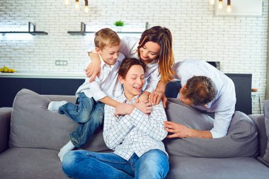 Mutlu aile birlikte kanepede oynarken eğleniyor
