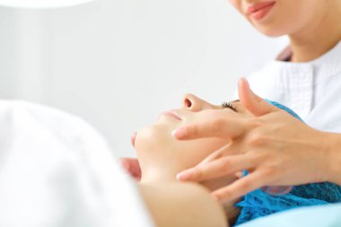 Şevval özçelik Güzellik yüz masajı için genç bir kadın yapar..