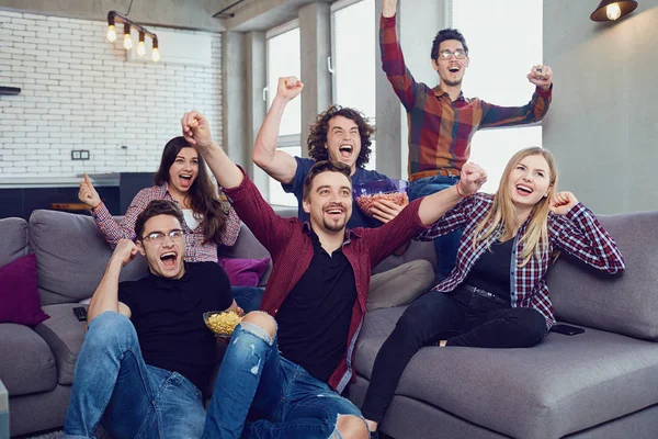 A group of friends are having fun watching TV in the room. — Stock Photo, Image