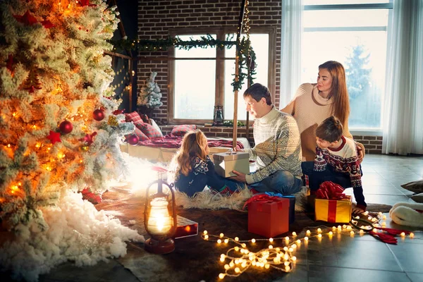 Familia jugando con regalos en el interior el día de Navidad . — Foto de Stock