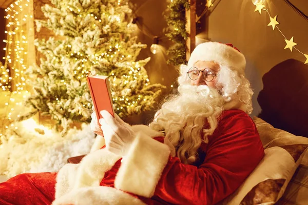 산타 클로스는 기독교에 벽난로와 방에서 책을 읽으십시오 — 스톡 사진