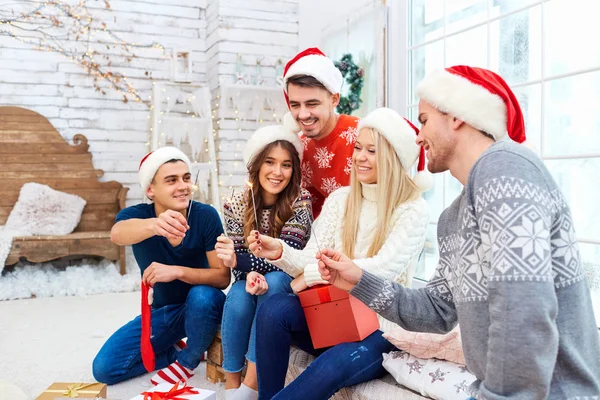 Um grupo de amigos com presentes em uma festa de Natal — Fotografia de Stock