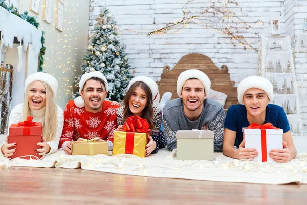 Um grupo de amigos com presentes em uma festa de Natal — Fotografia de Stock