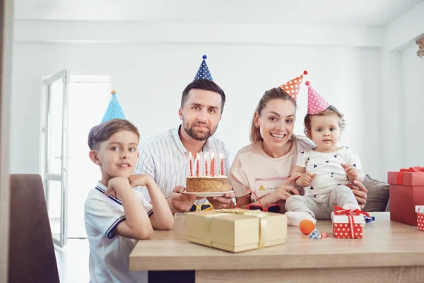 Μια οικογένεια με μια τούρτα κερί γιορτάζει ένα πάρτι γενεθλίων. — Φωτογραφία Αρχείου