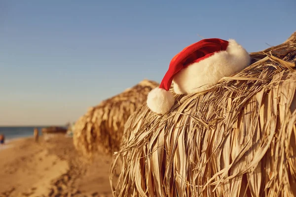 クリスマスの日にビーチでサンタ クロースの帽子. — ストック写真