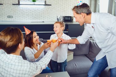 Bir aile bir mum pasta ile bir doğum günü partisi kutluyor.