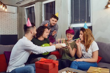 Arkadaş grubu Doğum günü partisi kutluyor mumlar ile pasta.