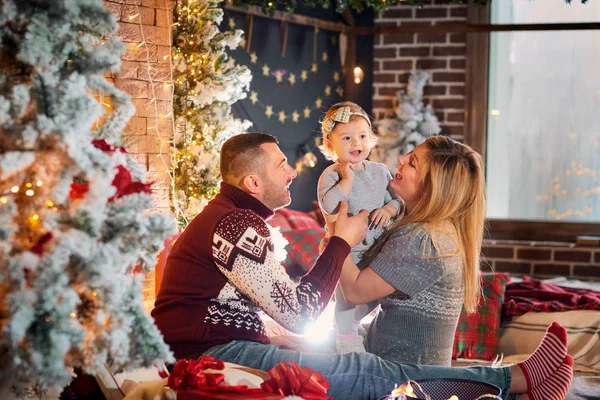 Familia feliz con un bebé en una habitación de Navidad . — Foto de Stock