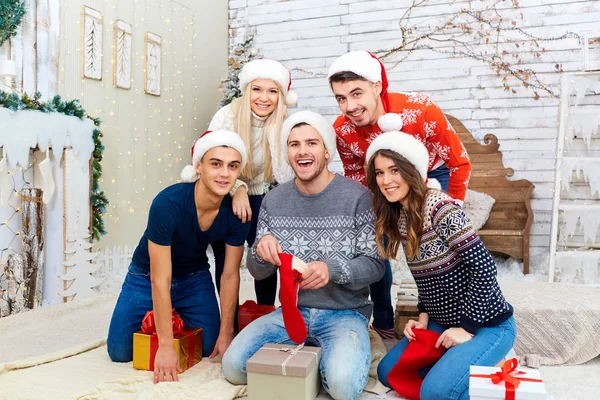 Um grupo de amigos com presentes em uma festa de Natal — Fotografia de Stock