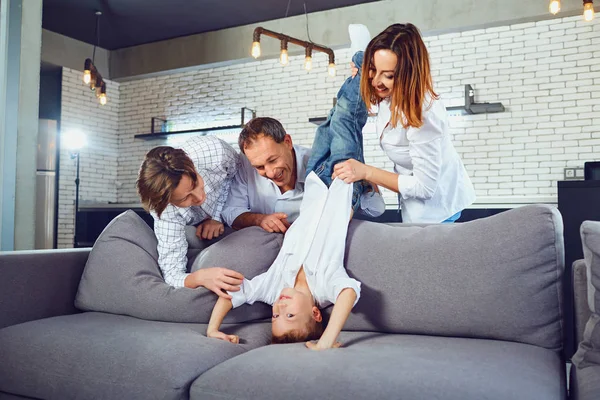 Een familie speelt op de Bank in de kamer. — Stockfoto