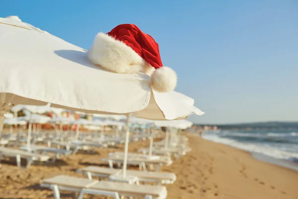 Czapka Świętego Mikołaja na plaży na Boże Narodzenie. — Zdjęcie stockowe