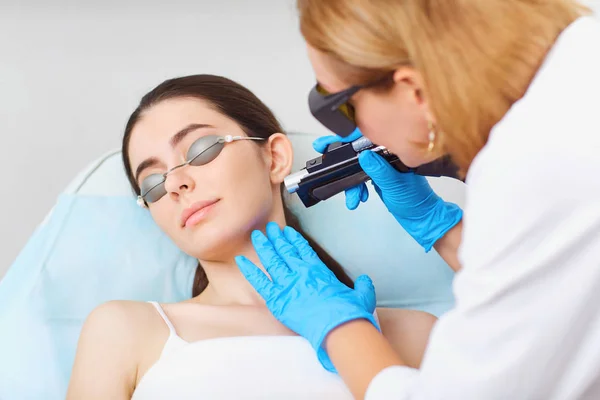 Laser hair removal on the face of a young woman in a cosmetology — Stock Photo, Image