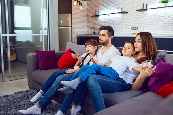 Família feliz descansando no quarto sentado no sofá . — Fotografia de Stock