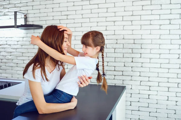 Mom and daughter are smiling, playing indoors — Stock Photo, Image
