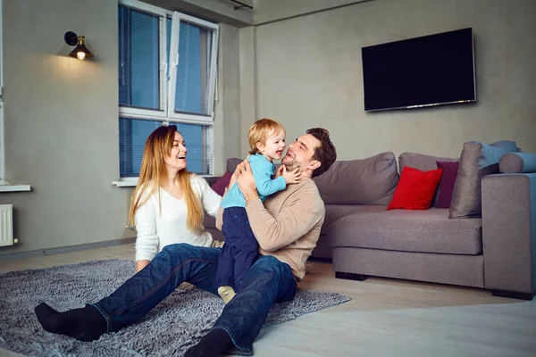 Eine glückliche Familie spielt mit einem Kind im Haus — Stockfoto