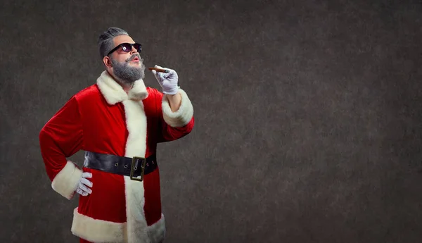 Papá Noel con un peinado de moda fuma un cigarro . — Foto de Stock