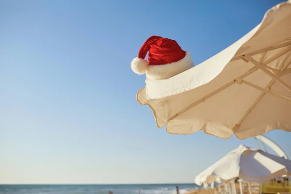 Czapka Świętego Mikołaja na plaży na Boże Narodzenie. — Zdjęcie stockowe