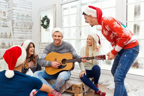 Un grupo de amigos con guitarra y cantando en casa en Navidad —  Fotos de Stock