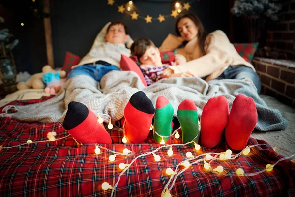 Calcetines de Navidad en los pies de una familia en Navidad . — Foto de Stock