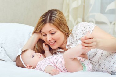 Mutlu bir anne ile bebek yatağı üzerinde çalış. 