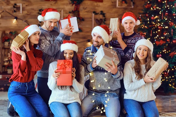 Amigos felizes com presentes sorrindo no Natal. — Fotografia de Stock