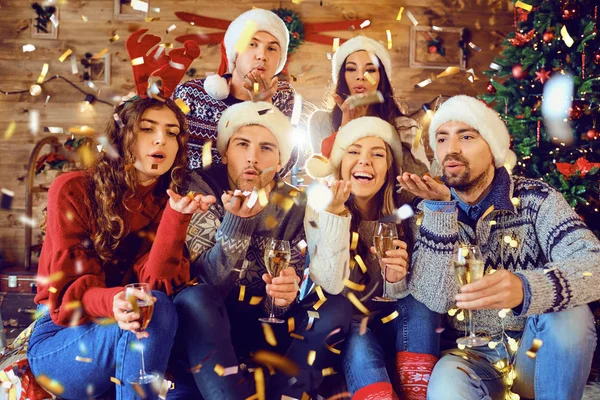 Glückliche Freunde mit fliegendem Konfetti zu Weihnachten. — Stockfoto