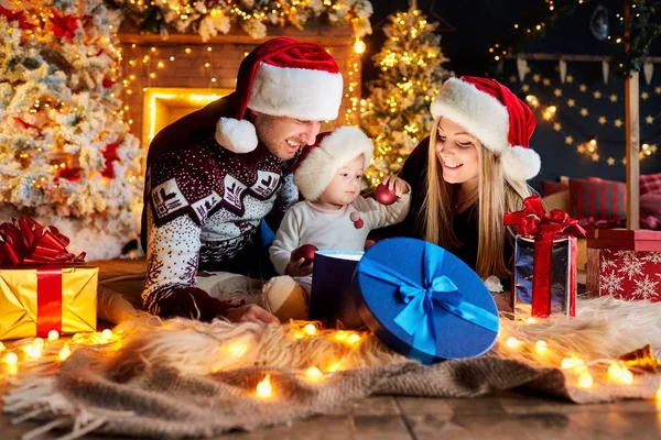 Happy family with a baby in a Christmas room. — Stock Photo, Image