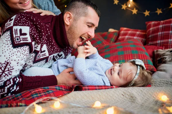 De familie met kind speelt binnenshuis op eerste kerstdag. — Stockfoto