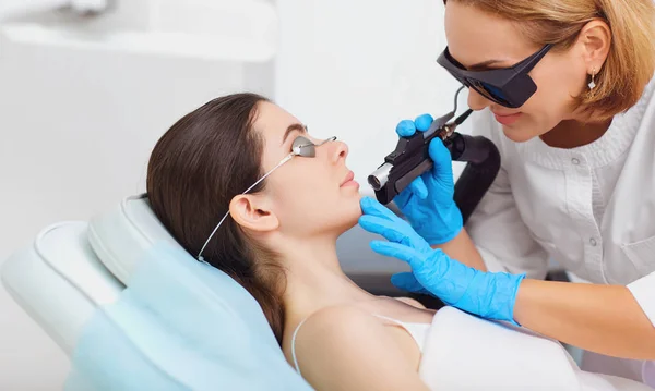 Depilazione laser sul viso di una giovane donna in una cosmetologia — Foto Stock