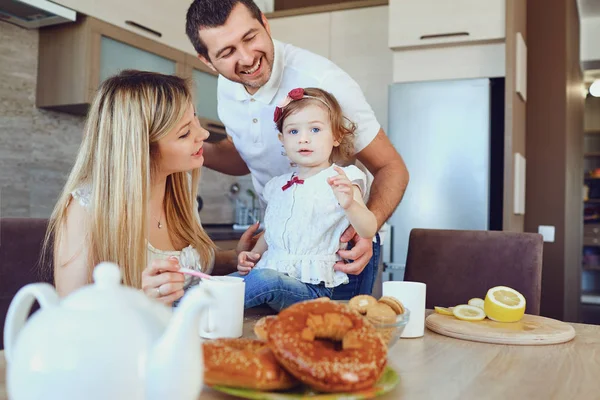 Eine glückliche Familie in der Küche, während sie am Tisch sitzt. — Stockfoto