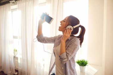 Bir kız Kulaklığımda pencereye bir şarkı söyler.