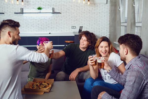 Een groep van vrienden is rammelende bril met bier in de kamer — Stockfoto