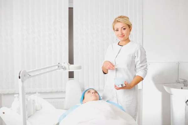 A female dermatologist examines the face of a girl in a cosmetol — Stock Photo, Image