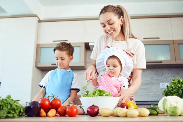 Mãe e filhos estão cozinhando na cozinha — Fotografia de Stock