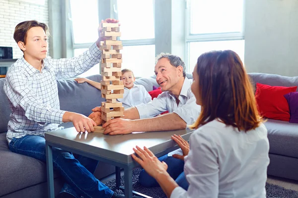 La famiglia gioca giochi da tavolo allegramente mentre siede a tavola . — Foto Stock