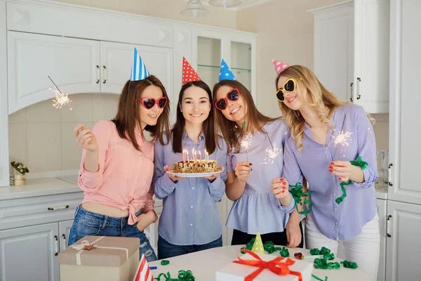 Eine Gruppe von Freundinnen mit einer Torte mit Kerzen feiert eine Geburt — Stockfoto