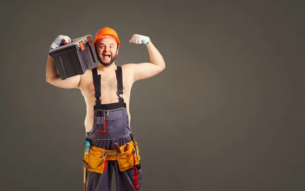 Witzige dickbärtige Bauarbeiter mit einem Werkzeugkasten. — Stockfoto