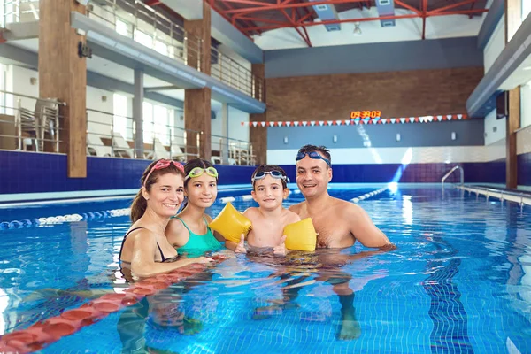 O familie fericită într-o piscină în interior . — Fotografie, imagine de stoc