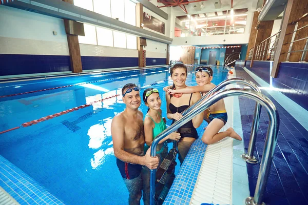 Een gelukkige familie lacht in het zwembad. — Stockfoto