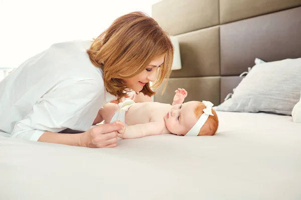 Una abuela feliz con un nieto bebé en la cama . — Foto de Stock